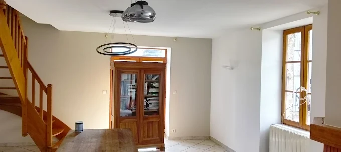 Pièce à vivre repeinte avec escalier en bois