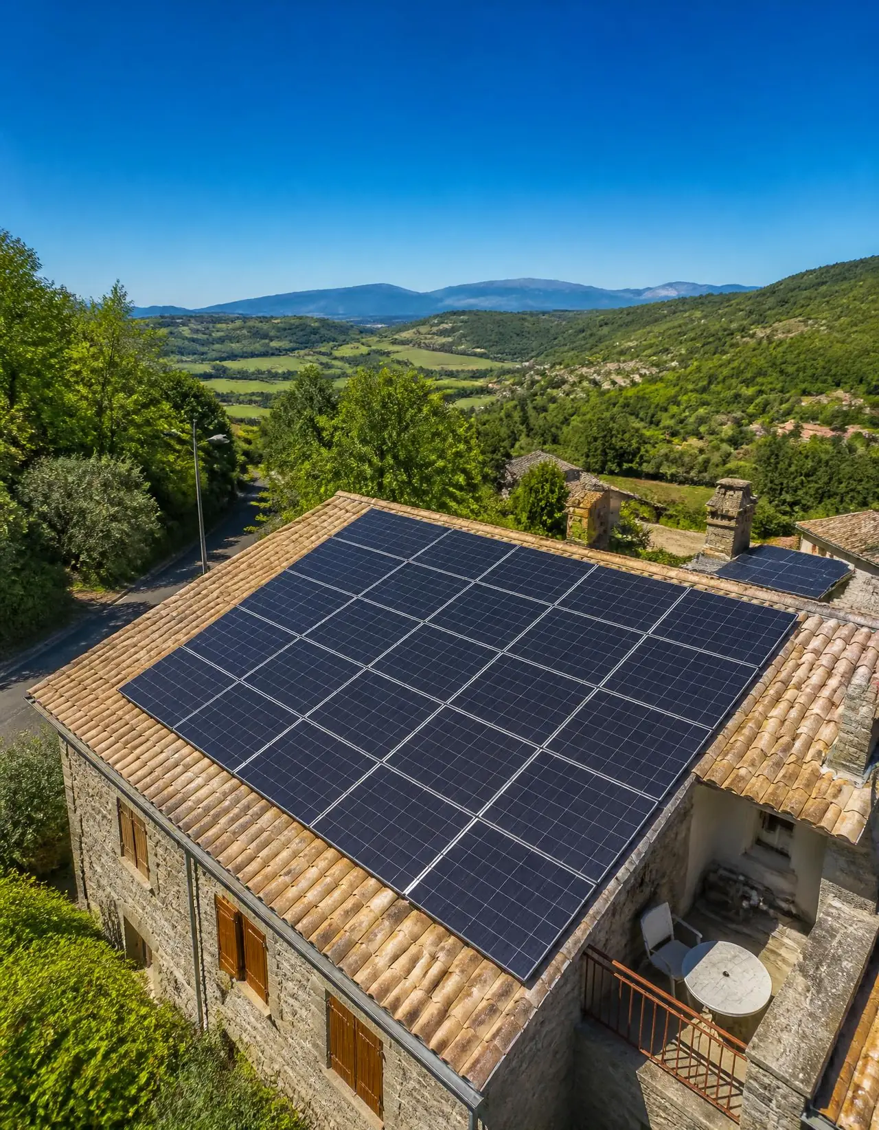 Illustration : maison en pierre au toit de tuiles couvert de panneaux solaires, au-dessus d’une vallée