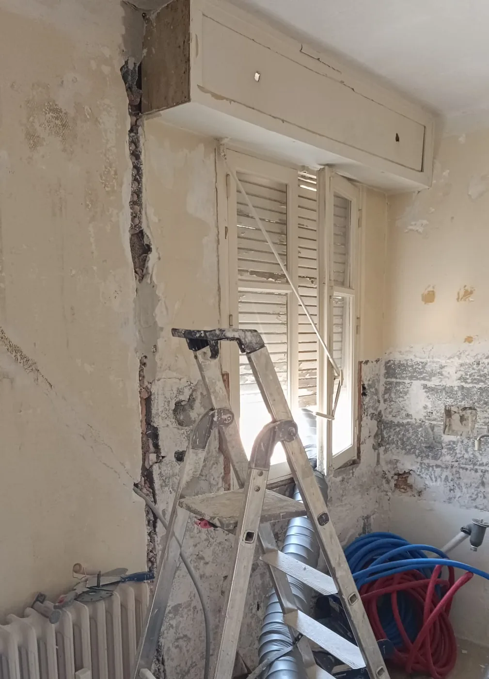 Saignée verticale creusée dans un mur décapé, enduit piqué jusqu'à la pierre