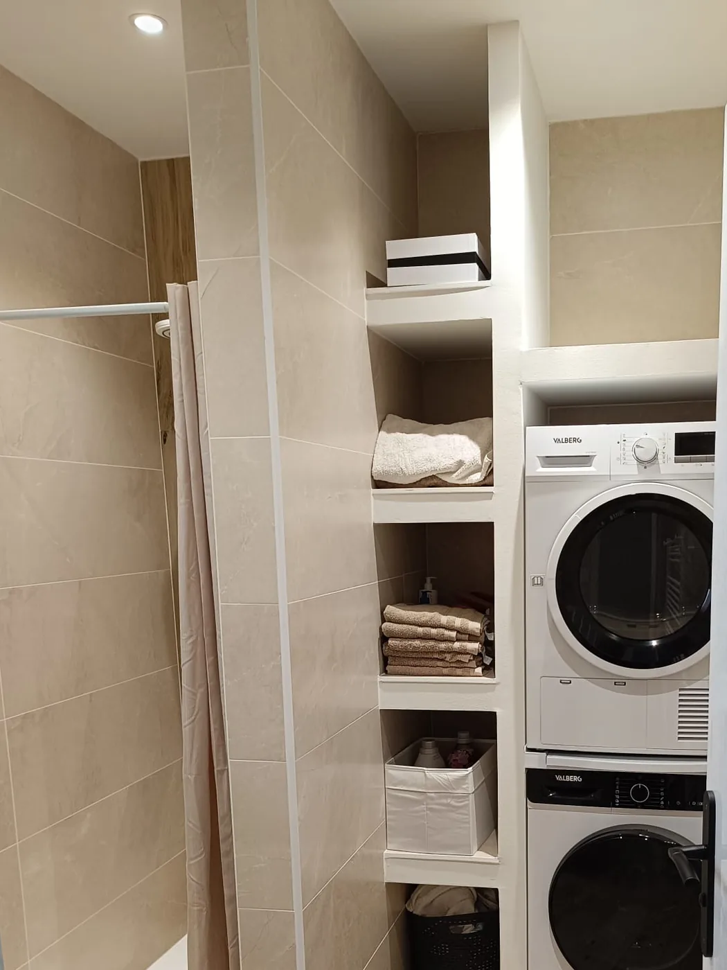 La même salle d'eau terminée : douche carrelée et colonne de niches garnie