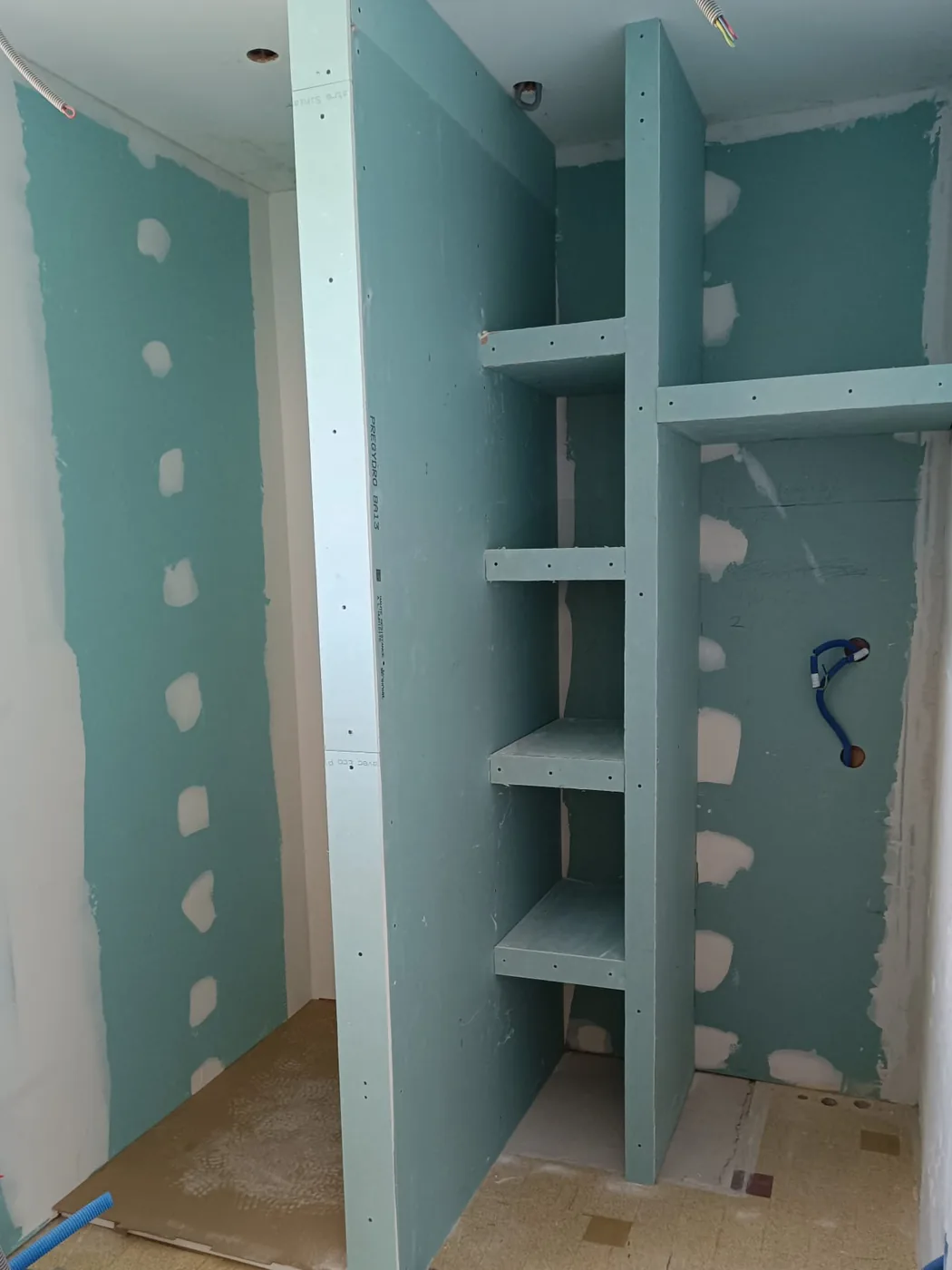 La même salle d’eau qu’en tête de page, avant carrelage : douche et colonne de niches montées en plaques de plâtre vertes