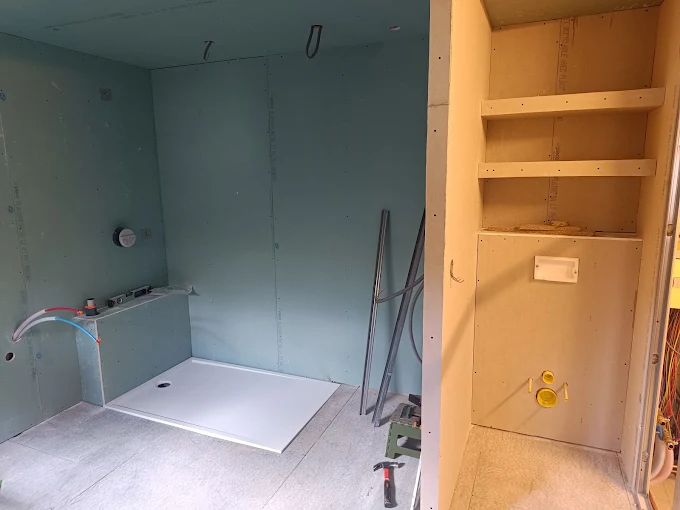 Salle de bains en travaux : cloisons montées et receveur de douche posé