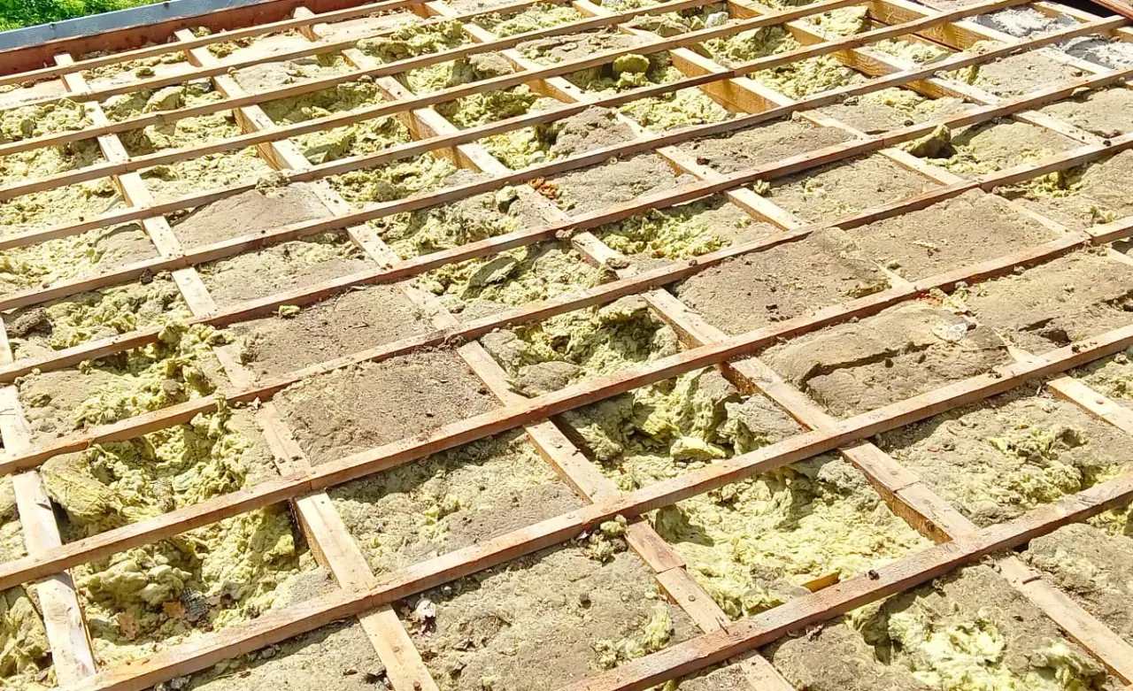Toiture découverte : liteaux en bois et ancien isolant jaune effrité en dessous