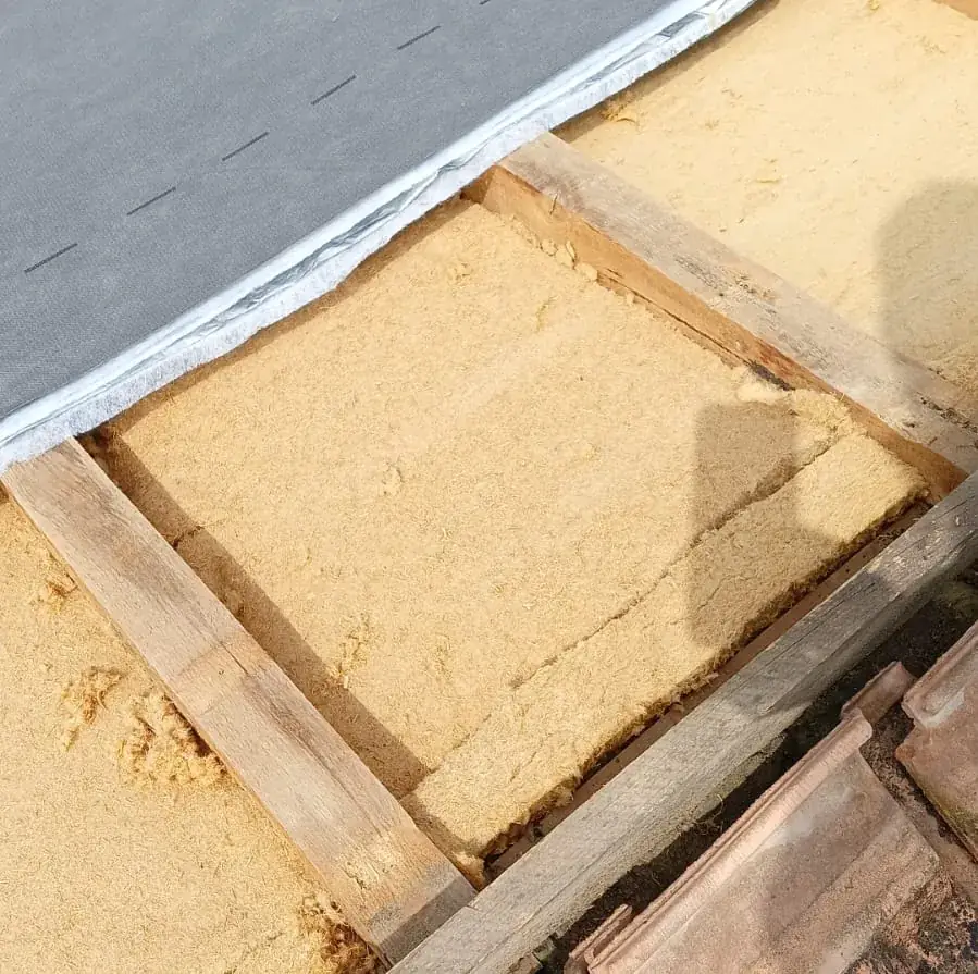 Panneaux isolants posés entre les chevrons d'une toiture